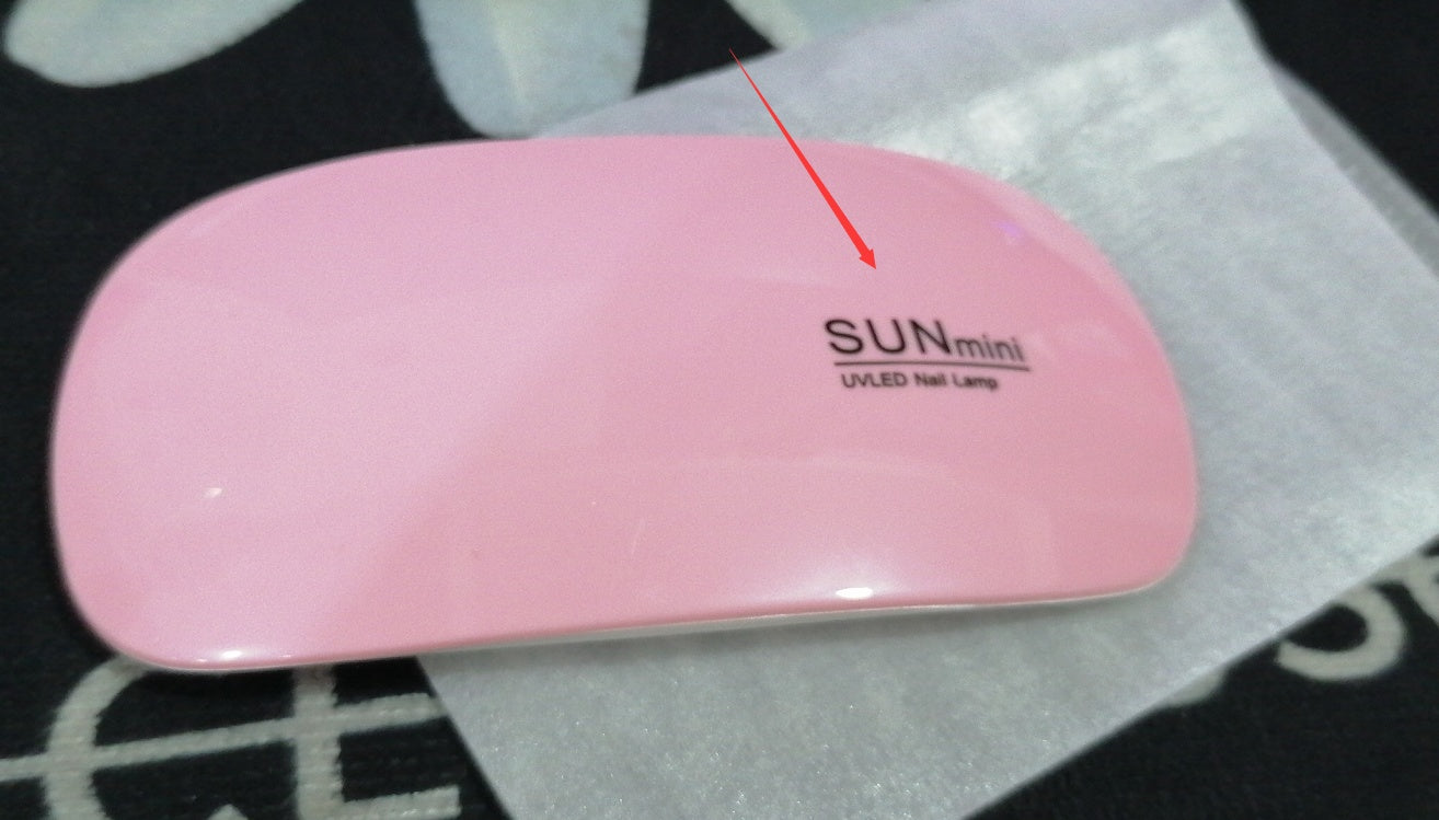 Portable pink LED light therapy nail lamp for quick drying.