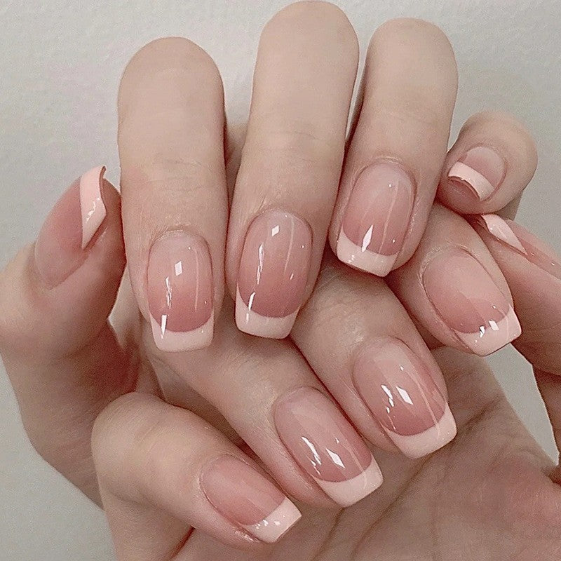 Oblique French style fake nails with glossy finish.