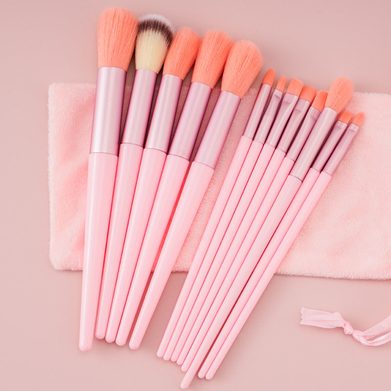 13Pcs makeup brush set with soft pink handles and matching pouch.