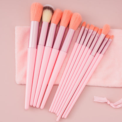 13Pcs makeup brush set with soft pink handles and matching pouch.