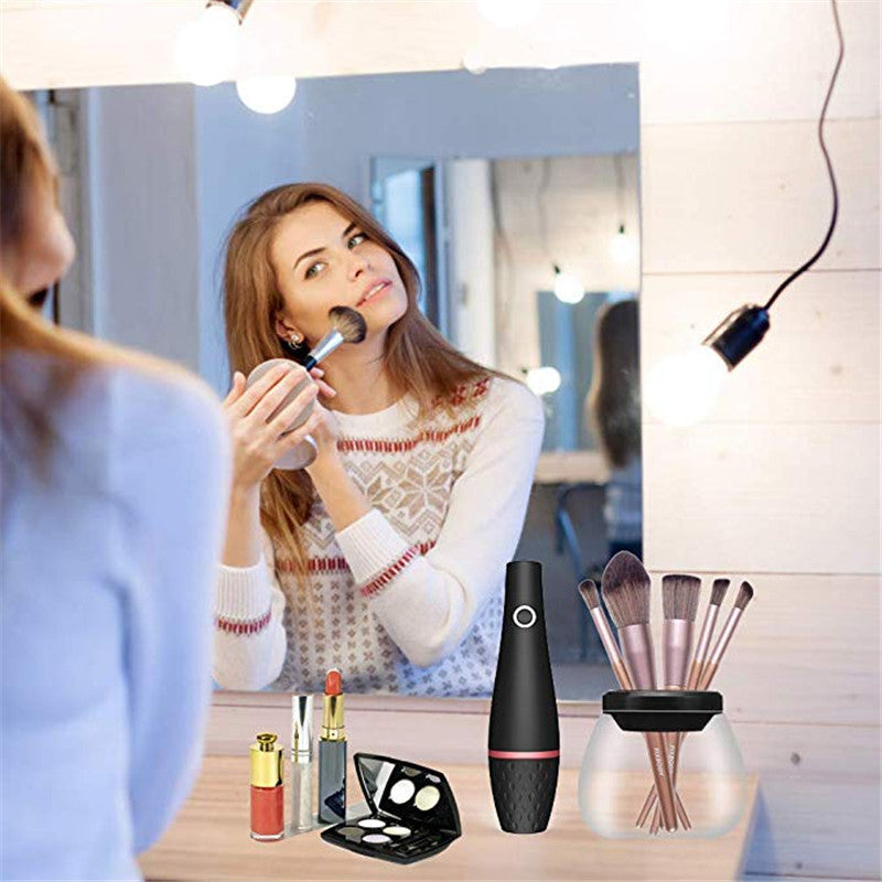 Electric makeup brush cleaner in black ABS material with charging power source on a vanity table.