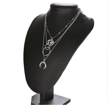 Fashionable multilayer Boho moon map necklace on display stand.