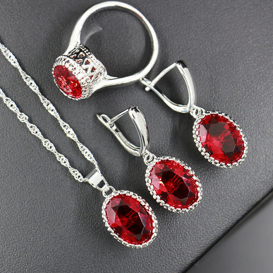 Bride wedding party jewelry set with ring, earrings, and necklace featuring red artificial gems and zircon on a platinum-plated design.