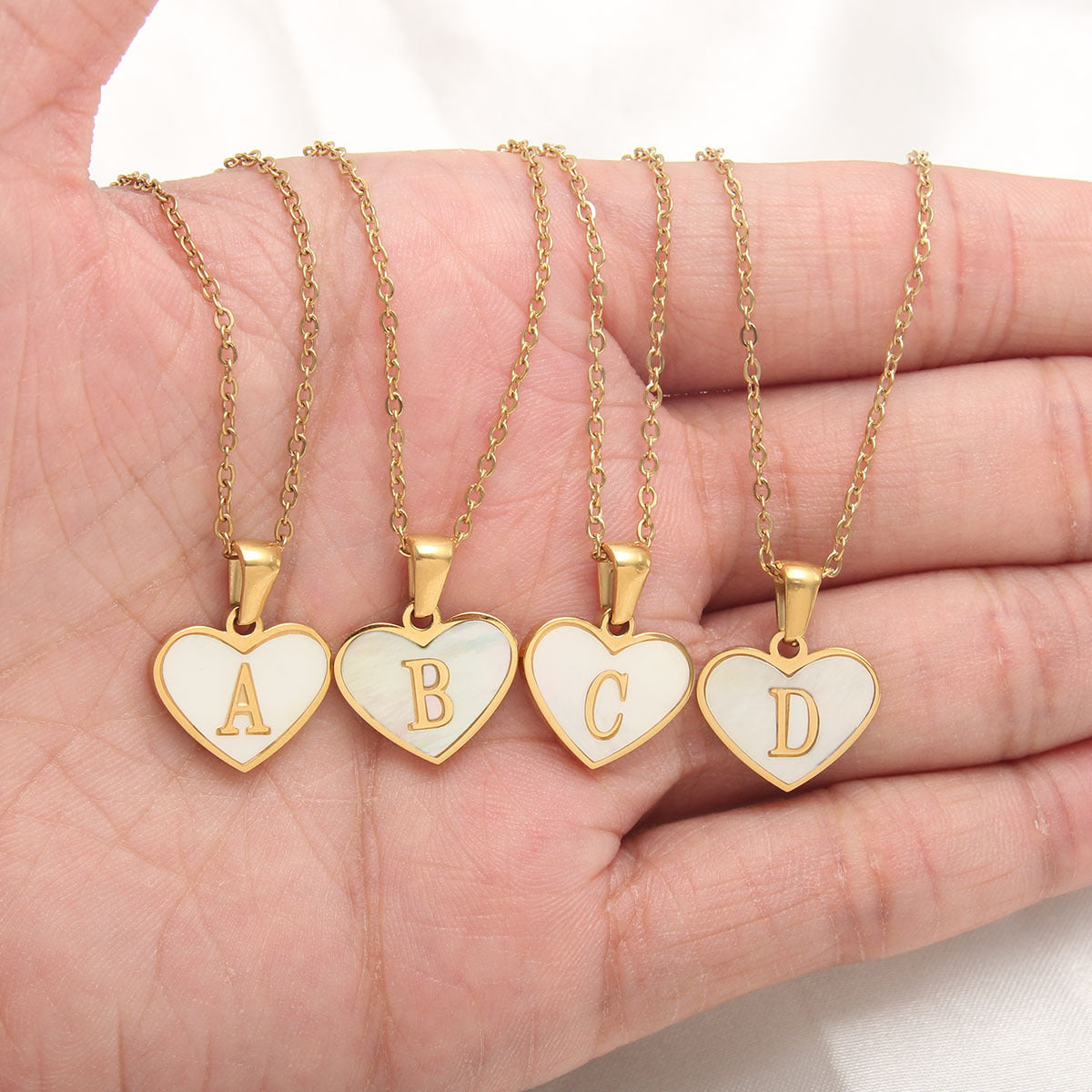 Heart-shaped 26 letter necklace with white shell and gold-plated chain.