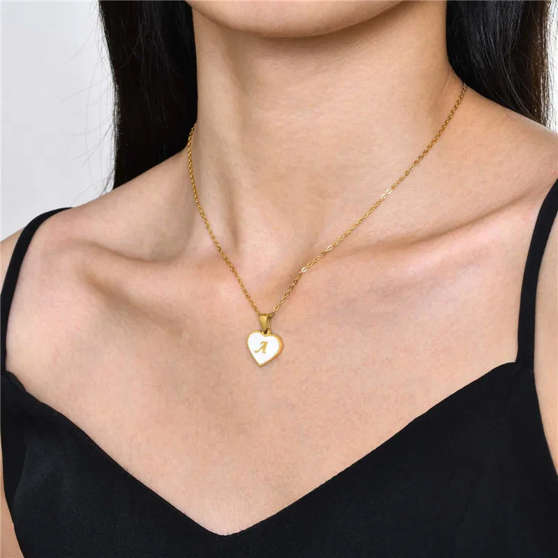 Heart-shaped 26 letter necklace with white shell pendant on woman, gold-plated chain fashion jewelry.